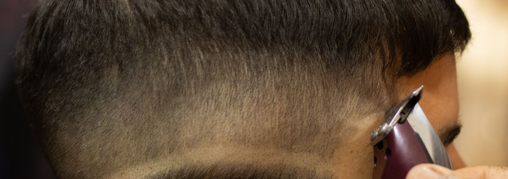 Barbier knipt een fade kapsel met de tondeuse