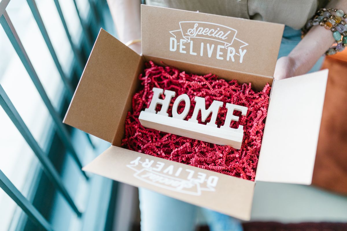 Open doos met houten letters HOME als housewarming cadeau