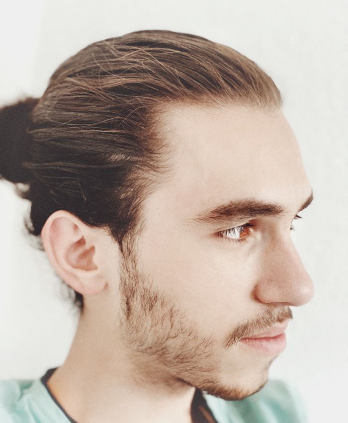 Man bun Zijaanzicht van een man met lang haar naar achteren in een man bun
