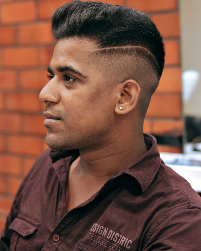 Pompadour met fade Man met een pompadour, geschoren scheiding en fade aan de zijkant