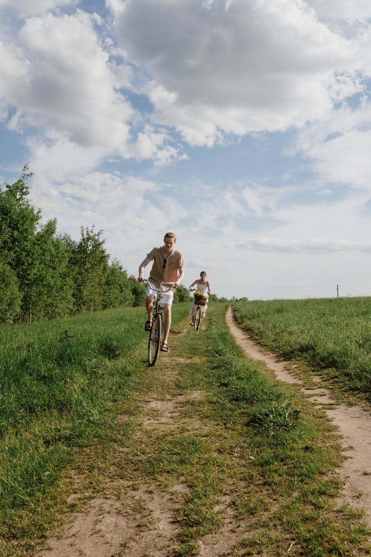 Stel fietst samen over een landweggetje tussen de velden